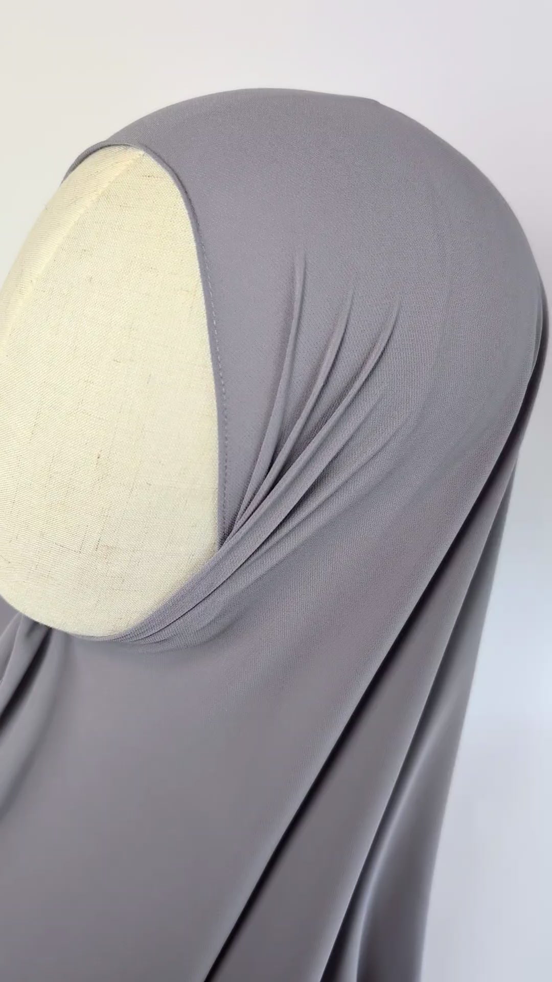 Close-up video of a light gray color chiffon hijab styled on mannequin head to show the soft texture of the chiffon hijab.