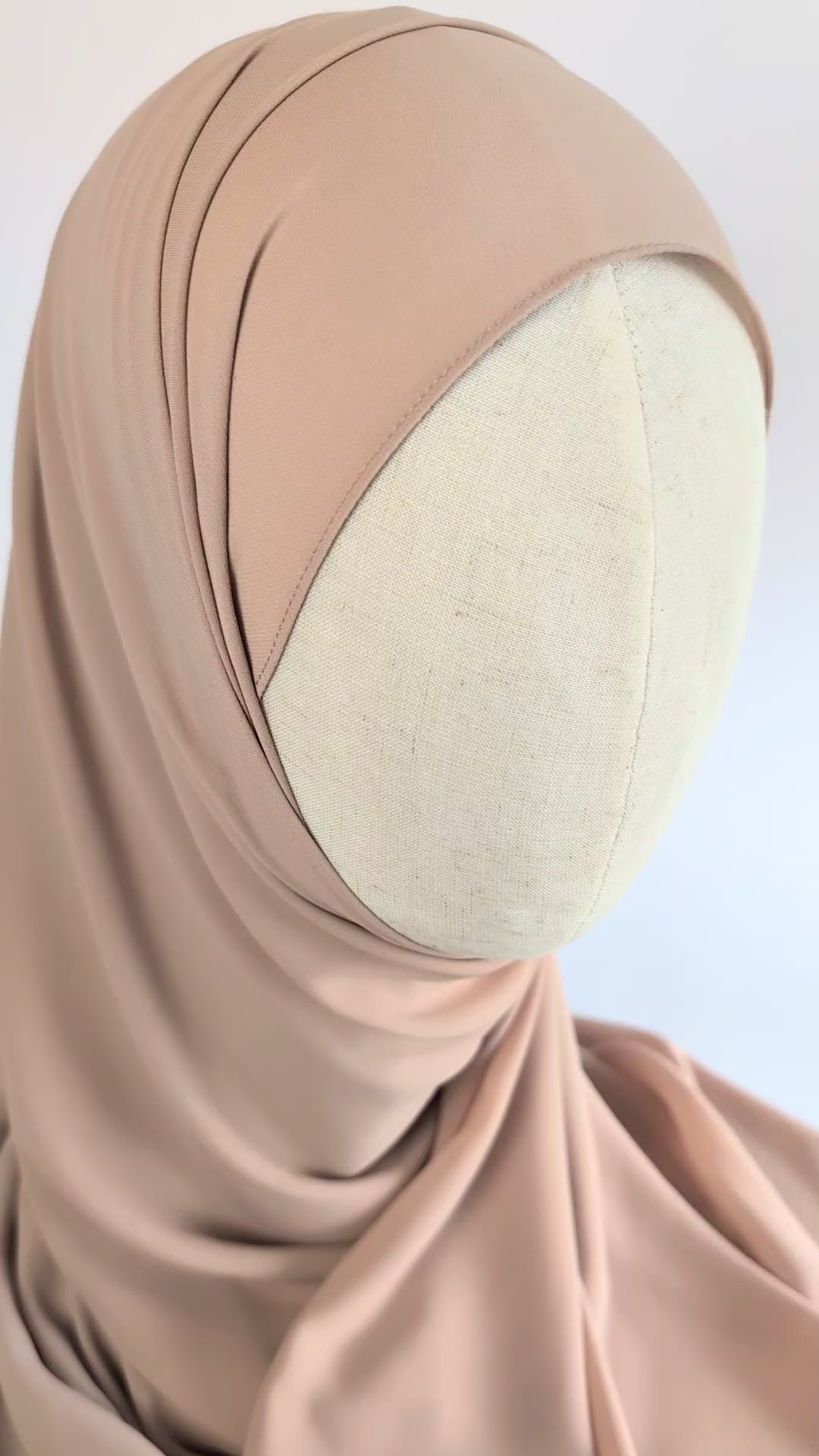 Close-up video of a soft beige color chiffon hijab styled on mannequin head to show the soft texture of the chiffon hijab and  how it would look once styled.