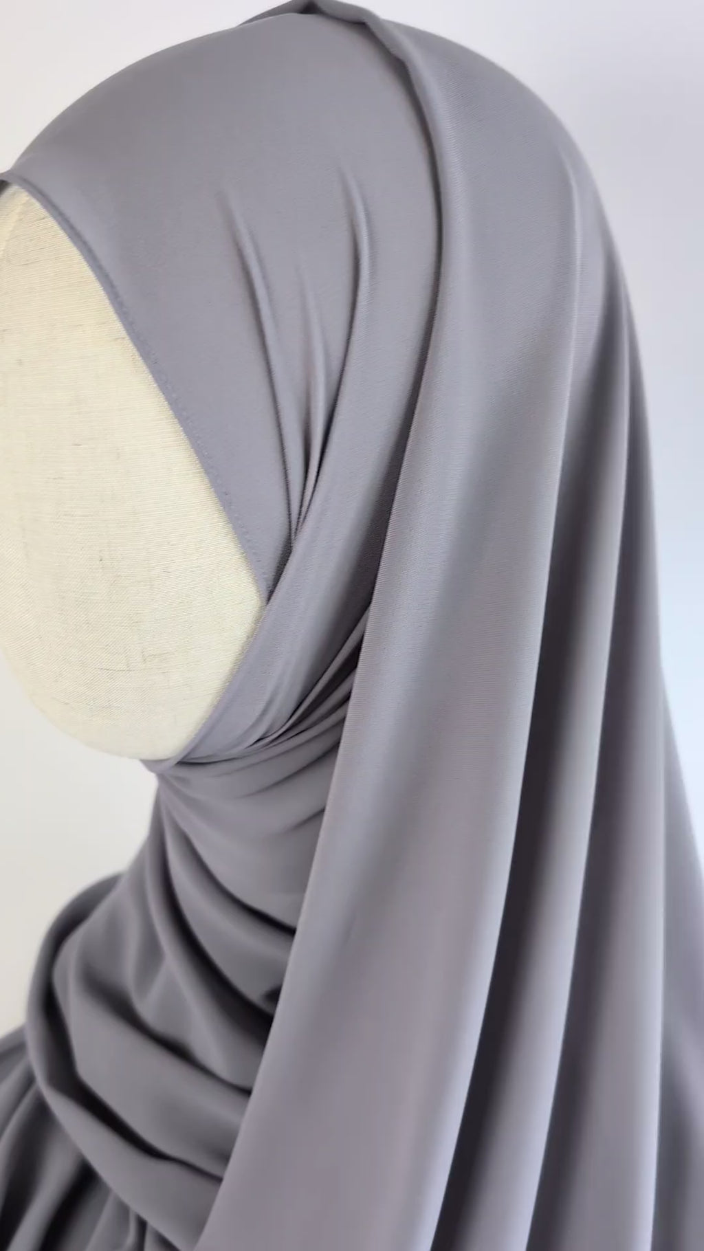 Close-up video of a light gray color chiffon hijab styled on mannequin head to show the soft texture of the chiffon hijab and  how it would look once styled.