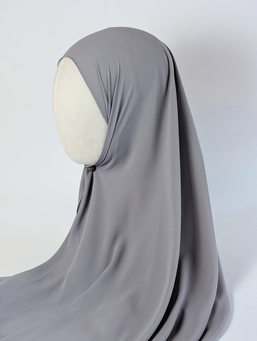 A solid gray chiffon hijab draped over a cream-colored mannequin head in side face shot view, photographed against a white background.